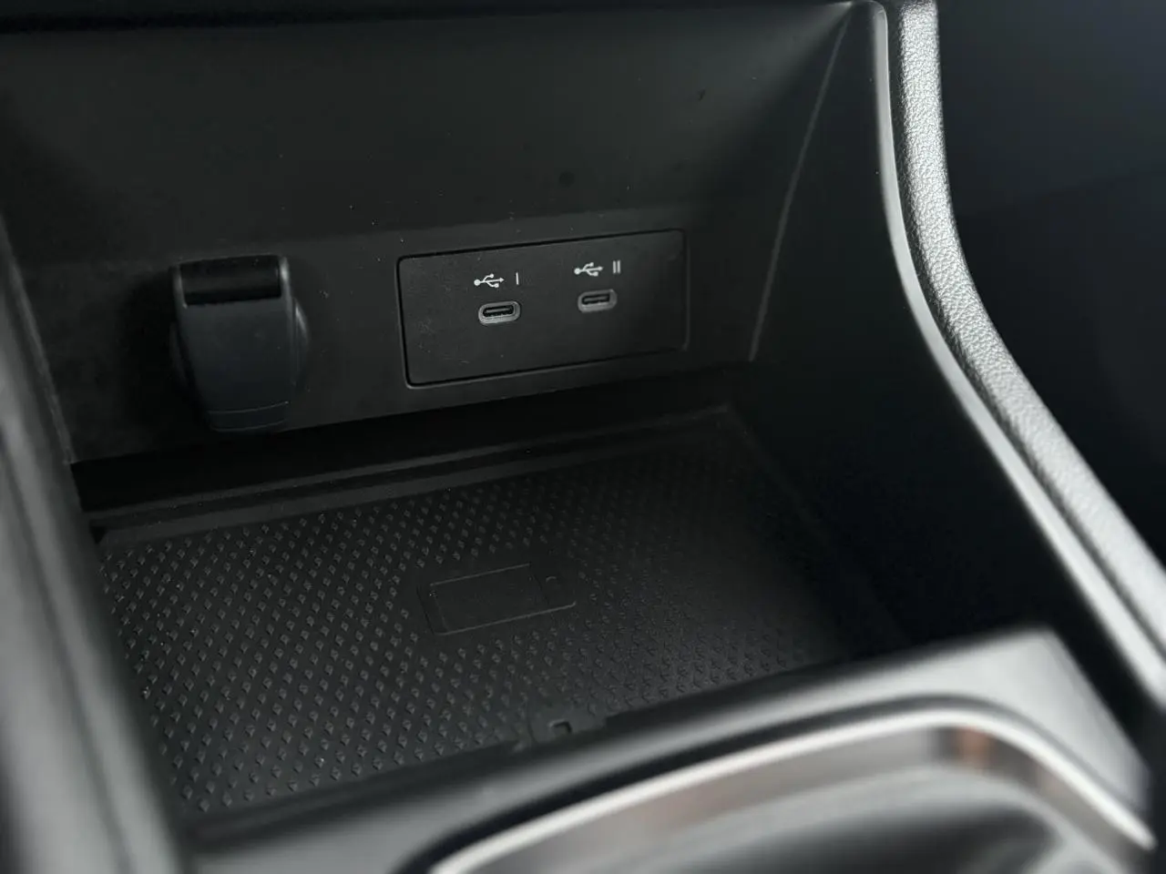 Gros plan sur la console centrale noire du Renault Captur 2025, montrant deux ports USB-C et un espace de rangement.