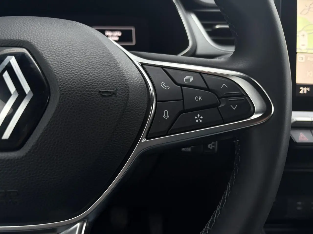 Gros plan sur la partie droite du volant noir du Renault Captur 2025 avec commandes multifonctions et tableau de bord numérique en arrière-plan.