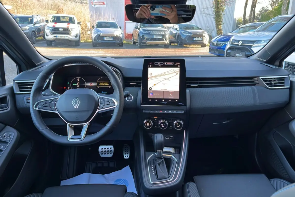 Vue intérieure avant du tableau de bord de la Renault Clio V E-Tech 145 Esprit Alpine avec écran tactile vertical et volant multifonctions.