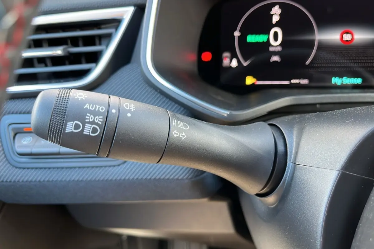 Gros plan sur la commande des feux et clignotants côté gauche du tableau de bord de la Renault Clio gris schiste 2025.