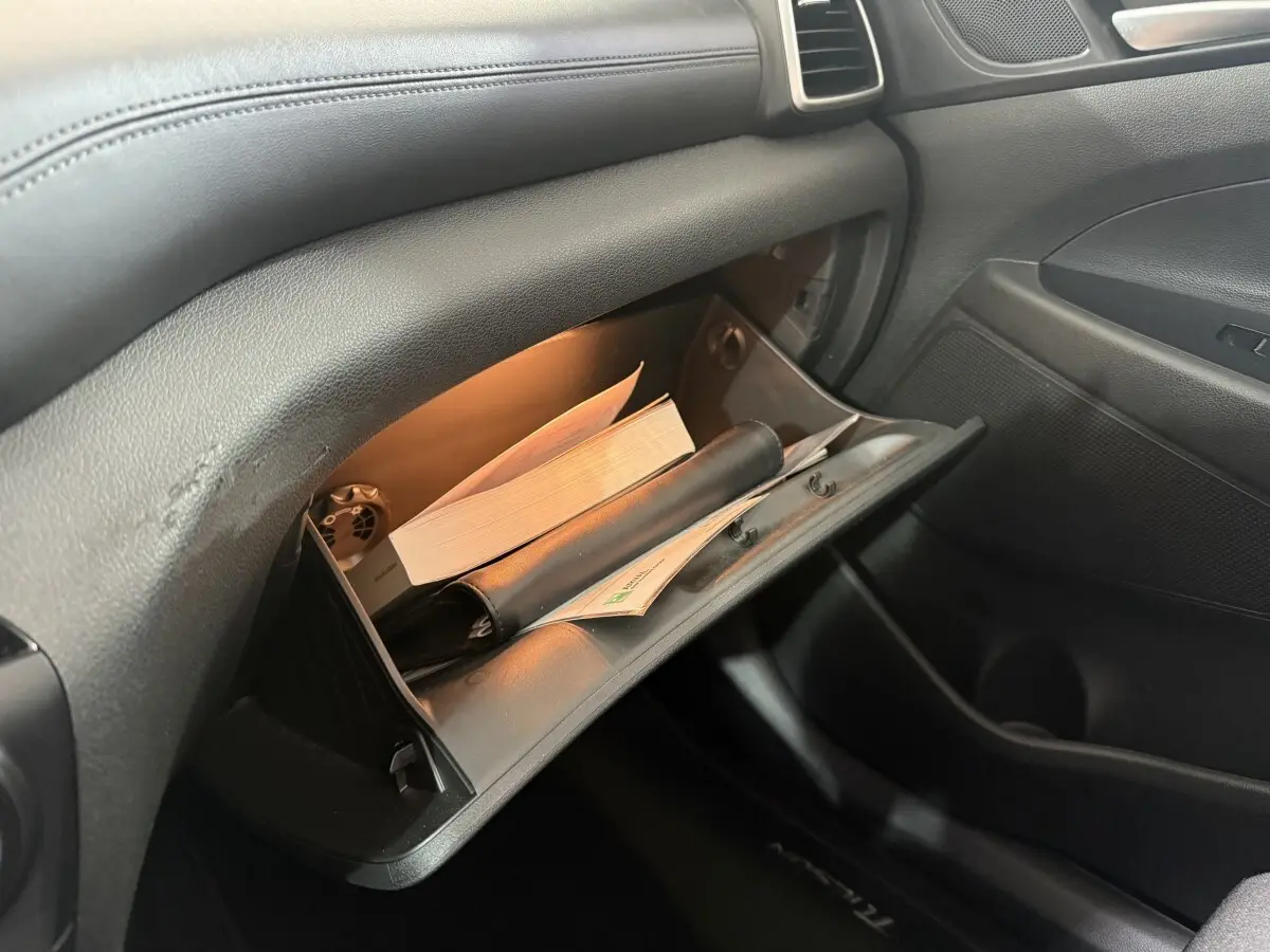 Boîte à gants ouverte éclairée dans l’habitacle noir du Hyundai Tucson 1.6 CRDI 136 Premium 2019.