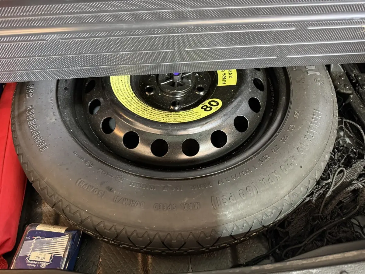 Vue rapprochée de la roue de secours noire dans le coffre du Hyundai Tucson 2019 noir, version diesel.