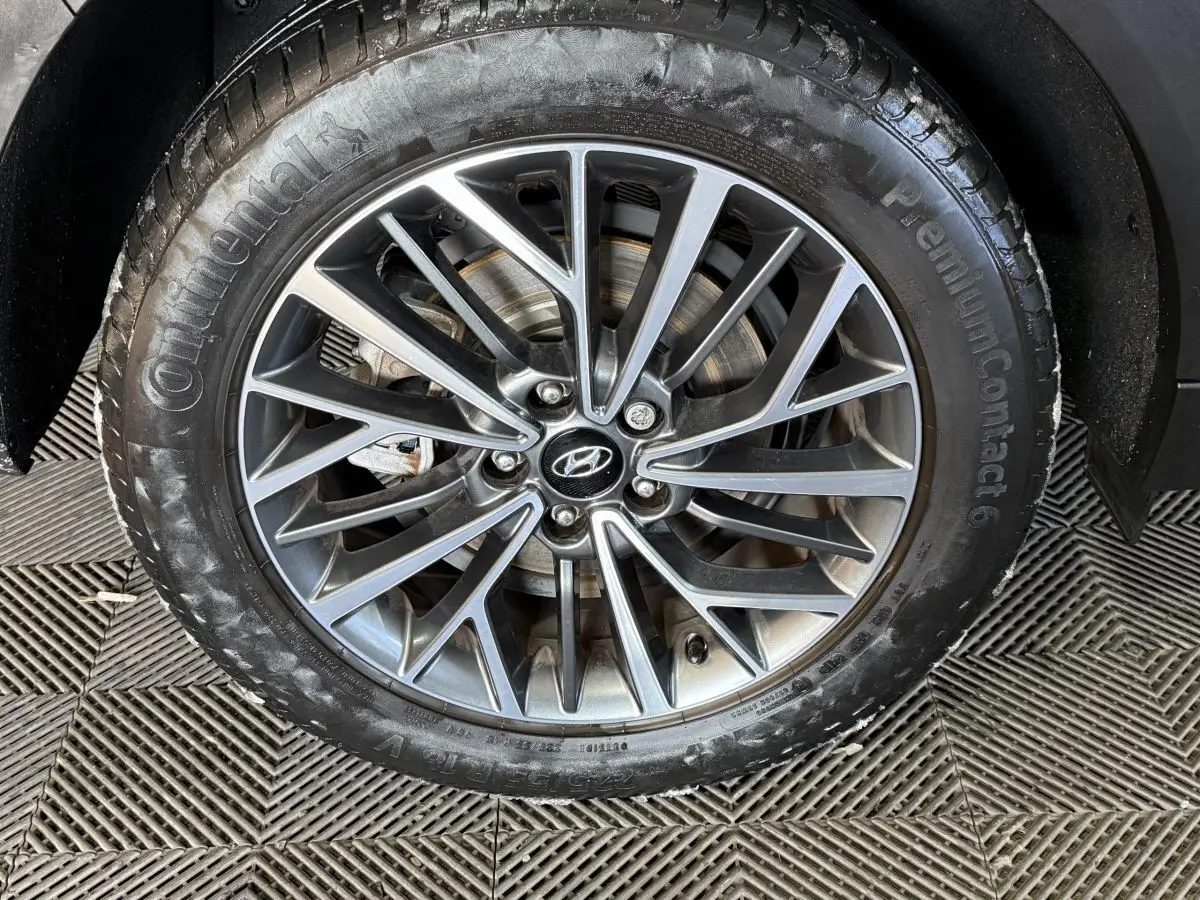 Gros plan sur la jante alliage grise et pneu Continental du Hyundai Tucson noir, vue latérale côté droit.
