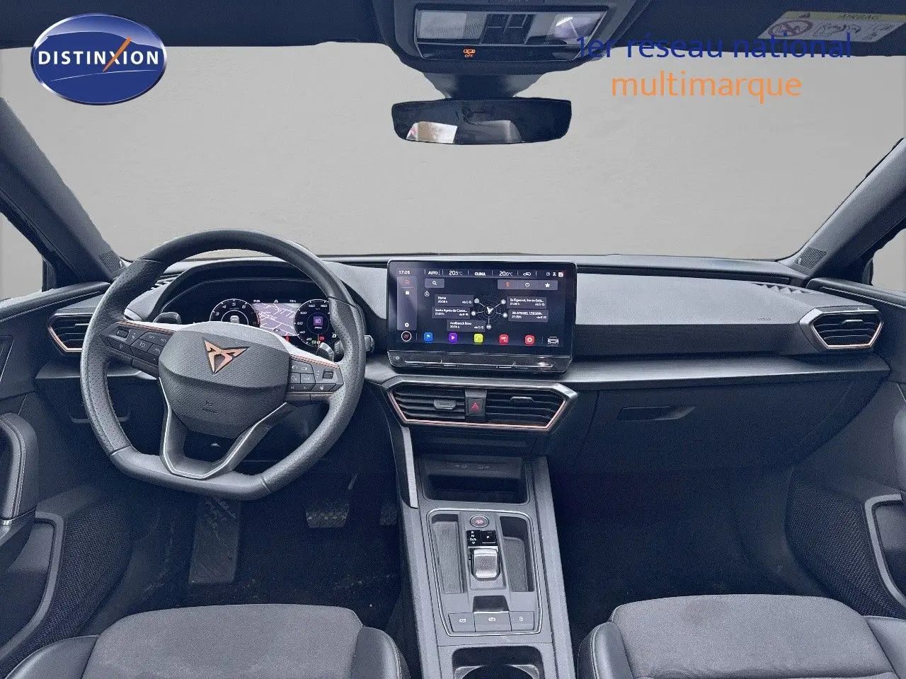 Vue frontale de l'habitacle du CUPRA LEON ST 2024, tableau de bord moderne avec écran tactile et volant multifonction.