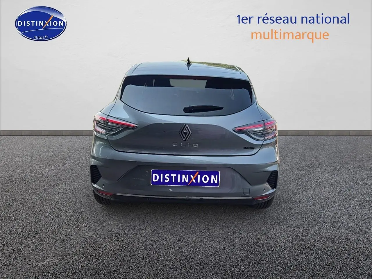 Vue arrière d'une Renault Clio V gris schiste avec feux LED et lunette arrière surteintée sur sol goudronné.