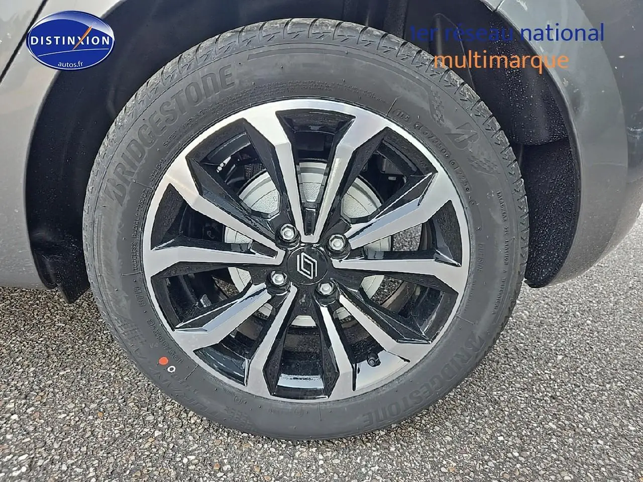 Gros plan sur la jante alu bicolore et pneu Bridgestone d'une Renault Clio V gris schiste, roue avant droite visible.