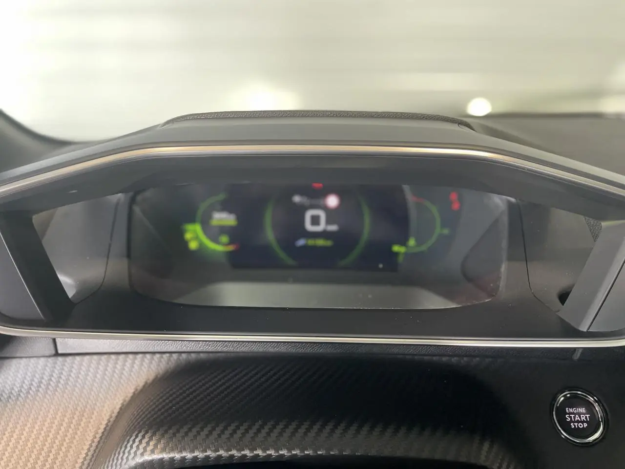 Tableau de bord numérique 3D du Peugeot 208 gris clair, avec bouton démarrage et finition carbone.