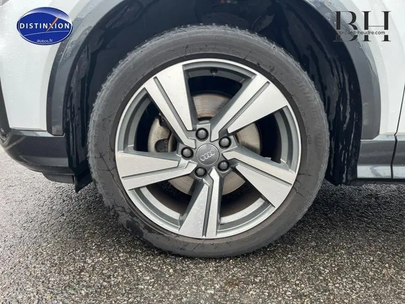 Gros plan sur la jante alu 18 pouces style 5 branches du côté avant gauche d’un Audi Q2 blanc Ibis.