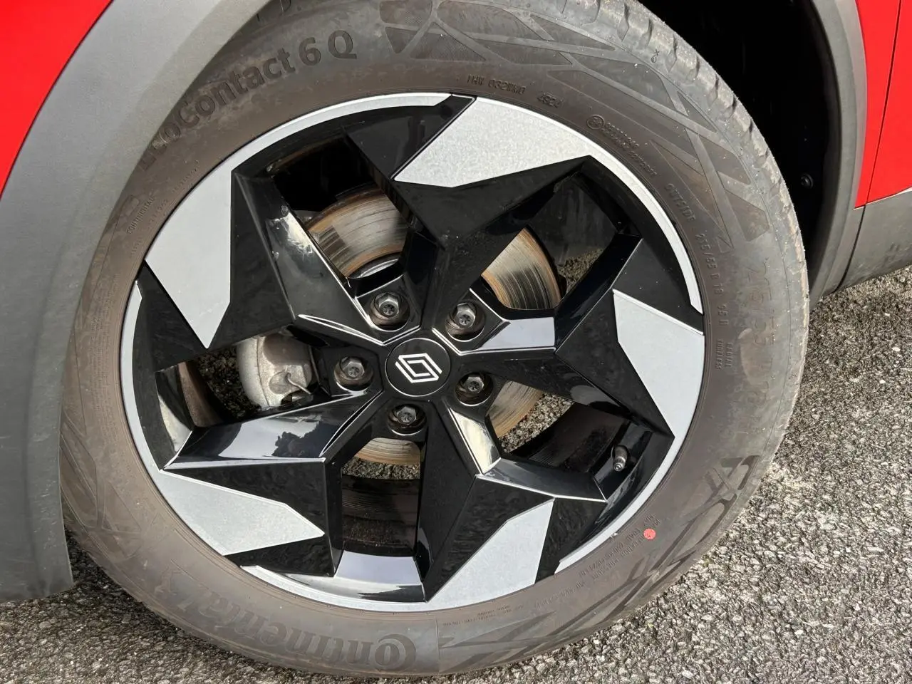 Gros plan sur la jante alu 18 pouces diamantée noire du côté gauche d’un Renault Captur Rouge Flamme / Noir.