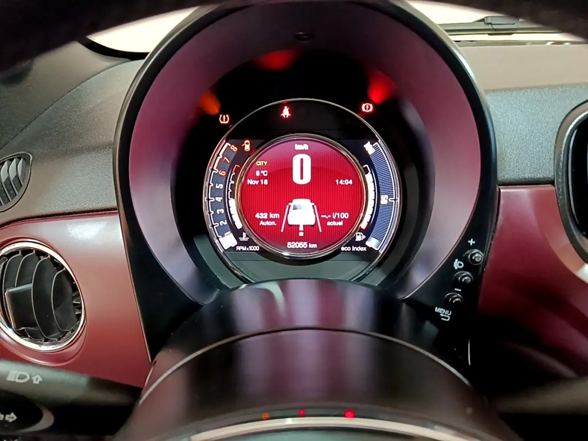 Gros plan sur le tableau de bord rouge de la Fiat 500 1.0 70ch BSG Star avec affichage numérique central lumineux.
