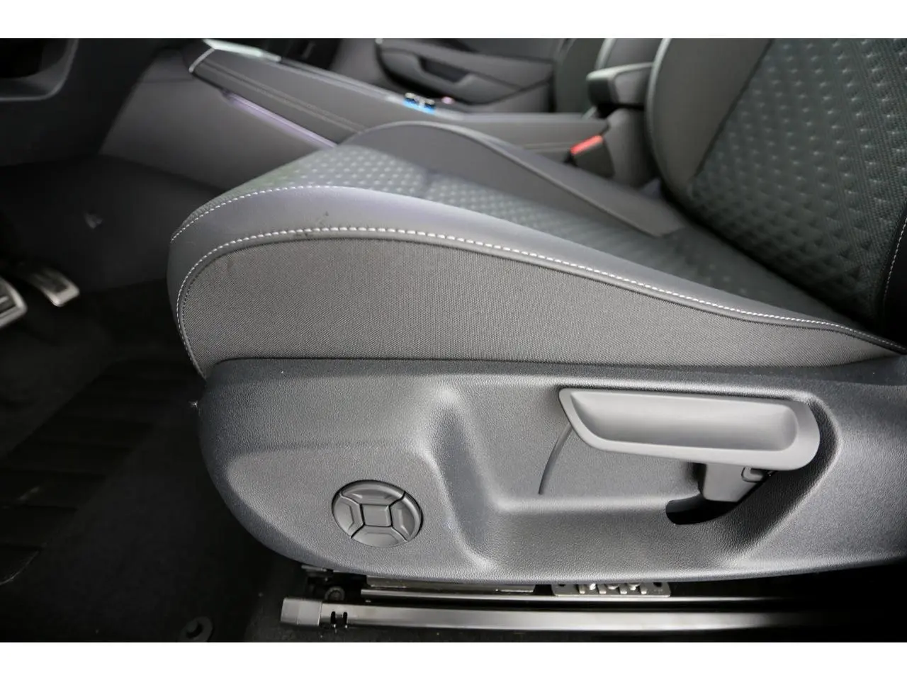 Gros plan sur le côté gauche du siège avant tissu gris avec coutures blanches du Volkswagen T-Roc 2026.