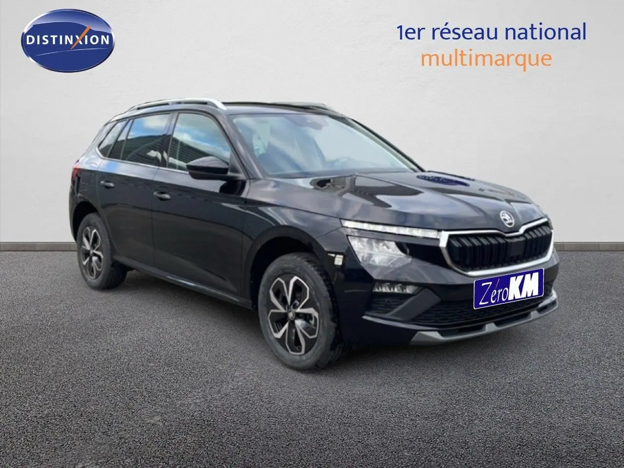 Vue 3/4 avant d'un Skoda Kamiq noir magique métal avec jantes bicolores et calandre distinctive.