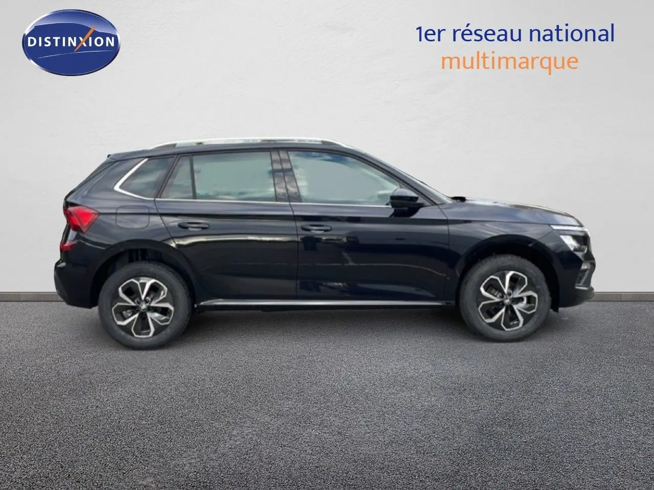 Vue de profil côté gauche d'un Skoda Kamiq noir magique métal avec jantes bi-ton et cinq portes visibles.