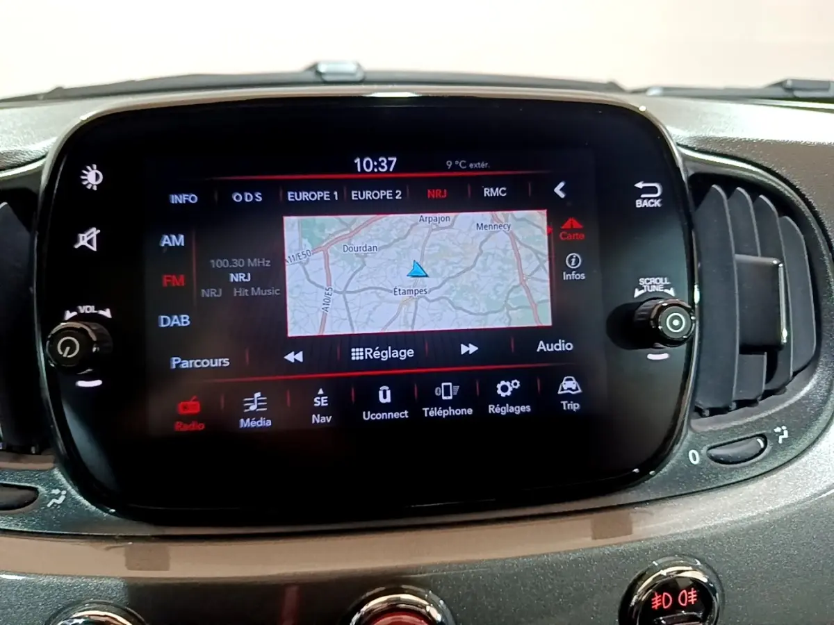 Écran tactile central de la Fiat 500 Hybrid gris foncé, affichant la navigation avec carte et réglages audio.