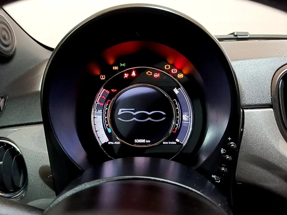 Vue rapprochée du tableau de bord circulaire de la Fiat 500 gris foncé, affichant les voyants d'alerte allumés.