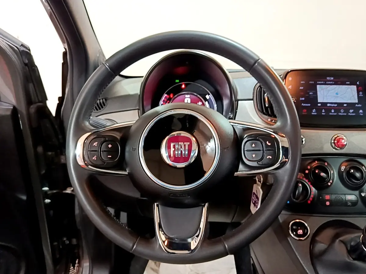 Vue centrée sur le volant cuir multifonctions noir du tableau de bord de la Fiat 500 gris foncé 2021.