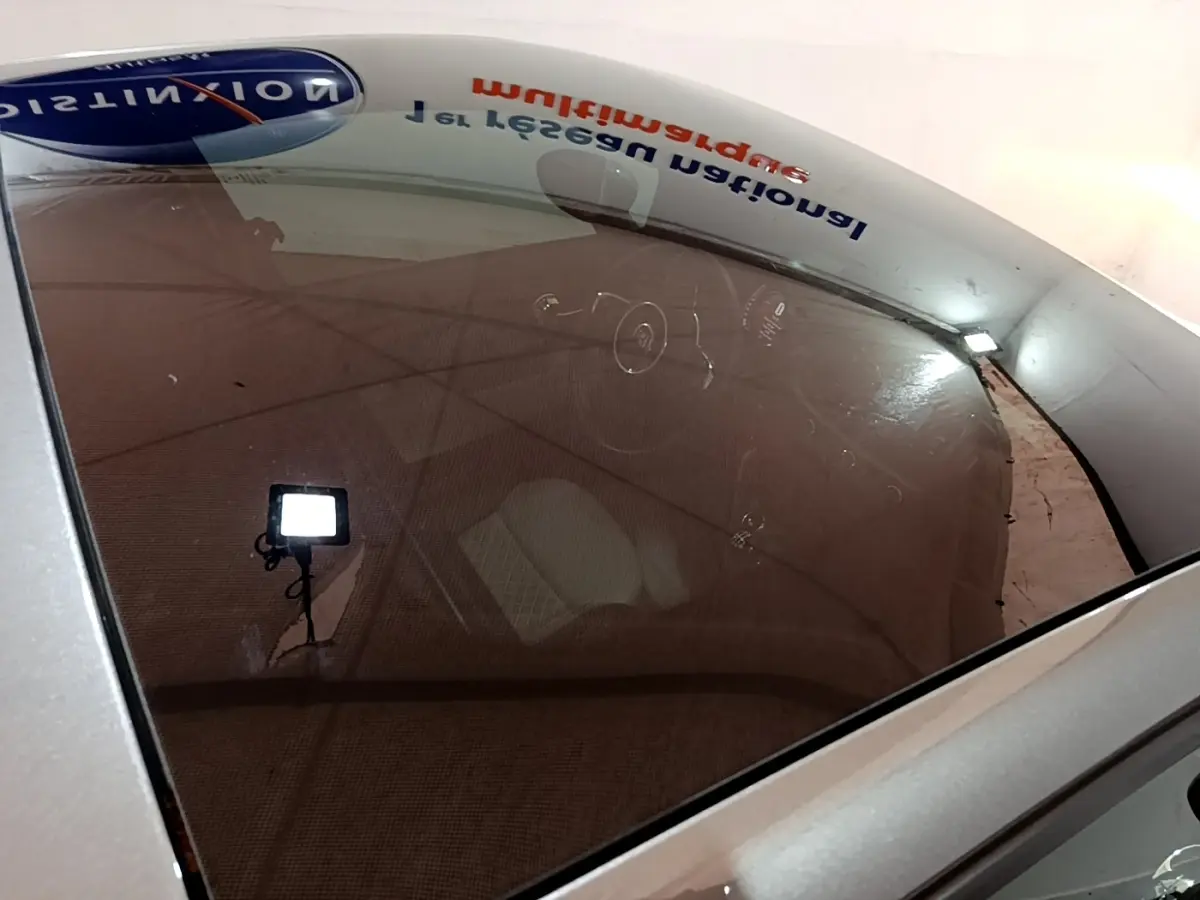 Vue plongeante sur l'intérieur d'une FIAT 500 gris foncé, mettant en valeur le volant cuir multifonctions et tableau de bord.