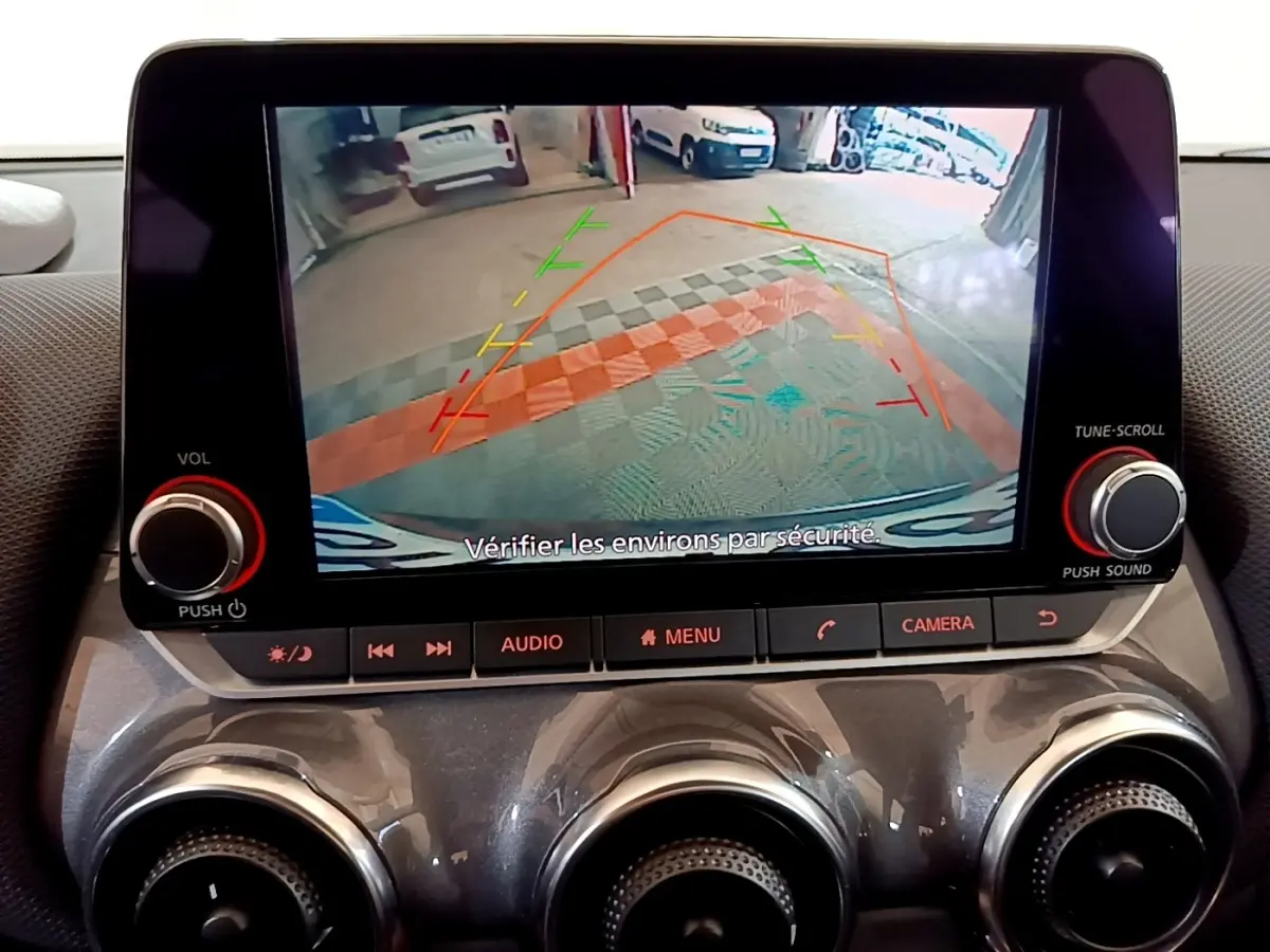 Écran tactile central du Nissan Juke noir 2023 montrant la caméra de recul avec lignes de guidage colorées.