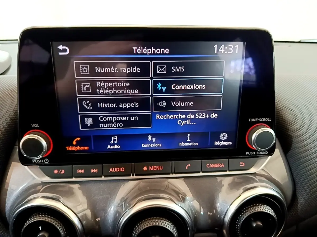 Écran tactile central du Nissan Juke 2023 affichant le menu téléphone avec commandes audio et caméra.
