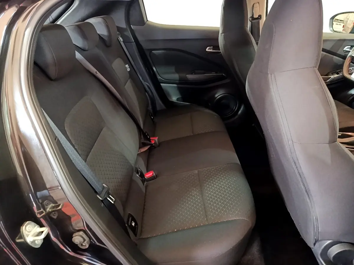 Vue intérieure côté gauche montrant la banquette arrière noire du Nissan Juke 2023 avec ceintures et appuie-têtes.