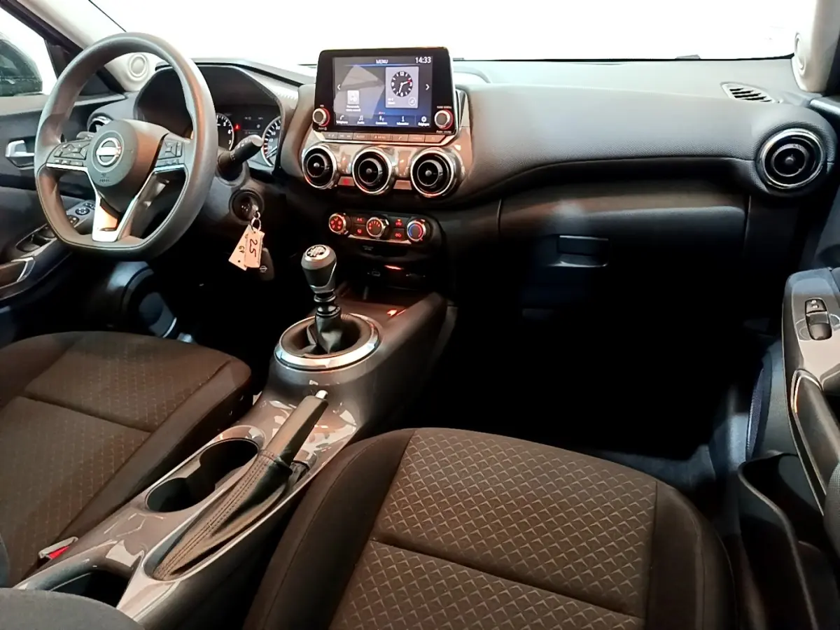 Intérieur noir du Nissan Juke 2023 vu côté conducteur, avec tableau de bord digital et boîte manuelle.