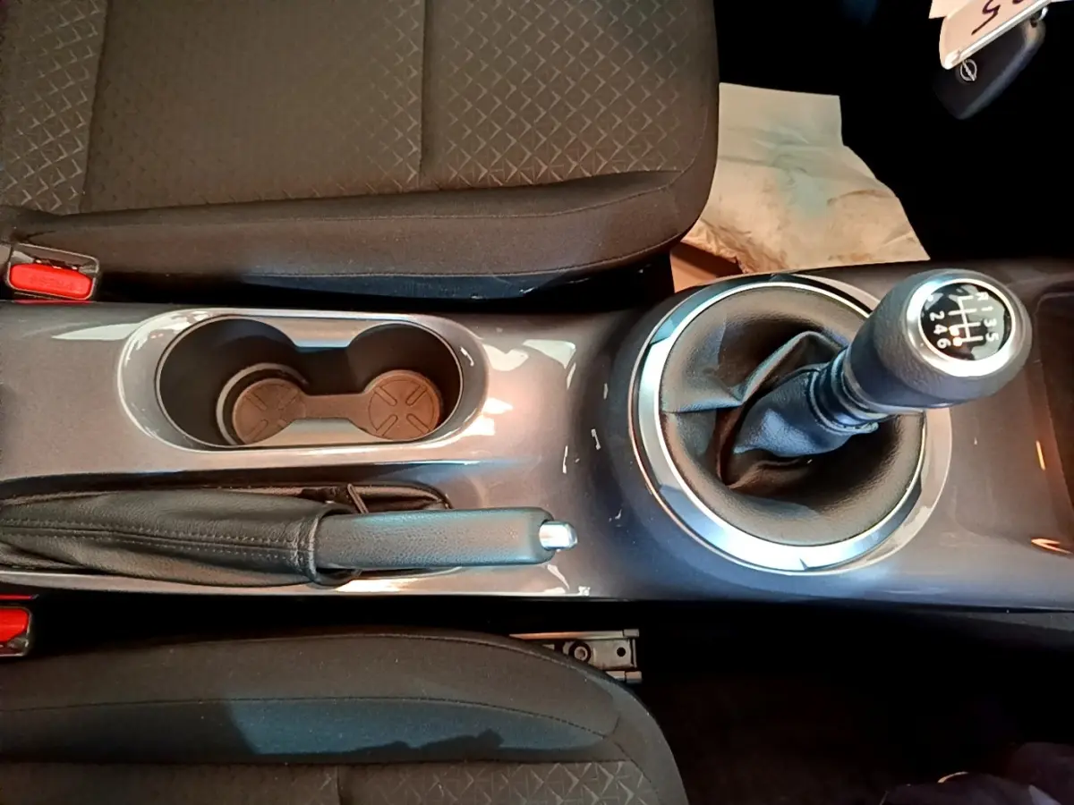 Vue plongeante sur la console centrale du Nissan Juke noir 2023, avec levier de vitesse manuel et frein à main.