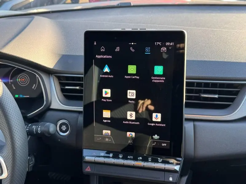 Vue intérieure centrée sur l'écran tactile multifonction du tableau de bord du Renault Captur rouge 2025.