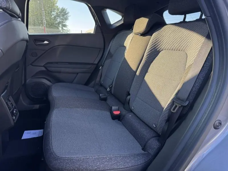 Vue latérale droite de la banquette arrière en tissu gris du Renault Captur 2025, avec ceintures de sécurité visibles.