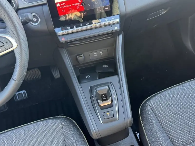 Vue intérieure centrée sur la console centrale et levier de vitesse du Renault Captur rouge flamme 2025, finition Techno.