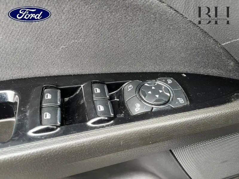 Gros plan sur les commandes de lève-vitres et réglage des rétroviseurs côté conducteur d'une Ford Mondeo SW gris Magnetic.