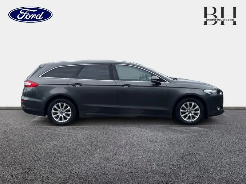 Profil droit d'une Ford Mondeo SW 2.0 TDCi 150ch Trend gris Magnetic avec jantes alu et vitres teintées.