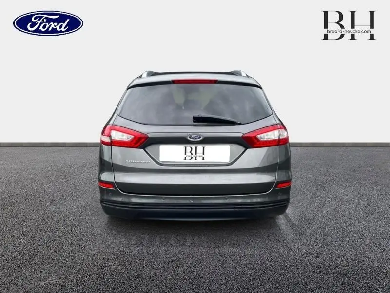 Vue arrière d'une Ford Mondeo SW gris Magnetic avec feux arrière LED et barres de toit visibles.