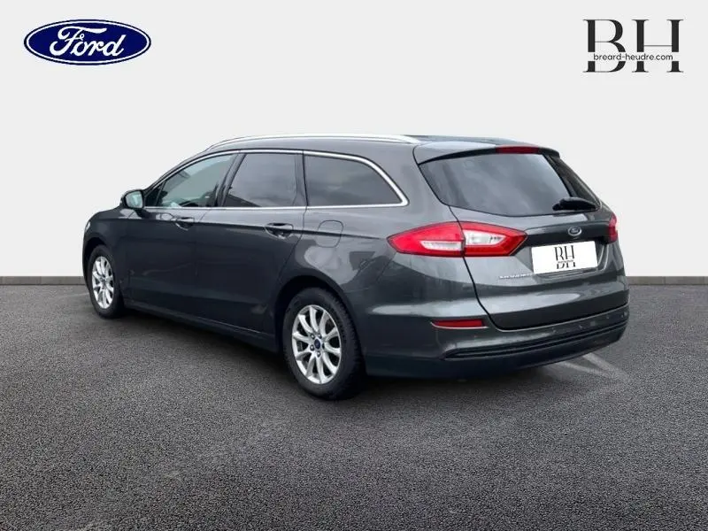 Vue 3/4 arrière droite d'une Ford Mondeo SW 2.0 TDCi 150ch Trend gris Magnetic avec jantes alu et vitres teintées.
