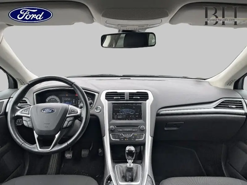 Vue intérieure avant du tableau de bord gris et volant cuir multifonction d'une Ford Mondeo SW 2016.