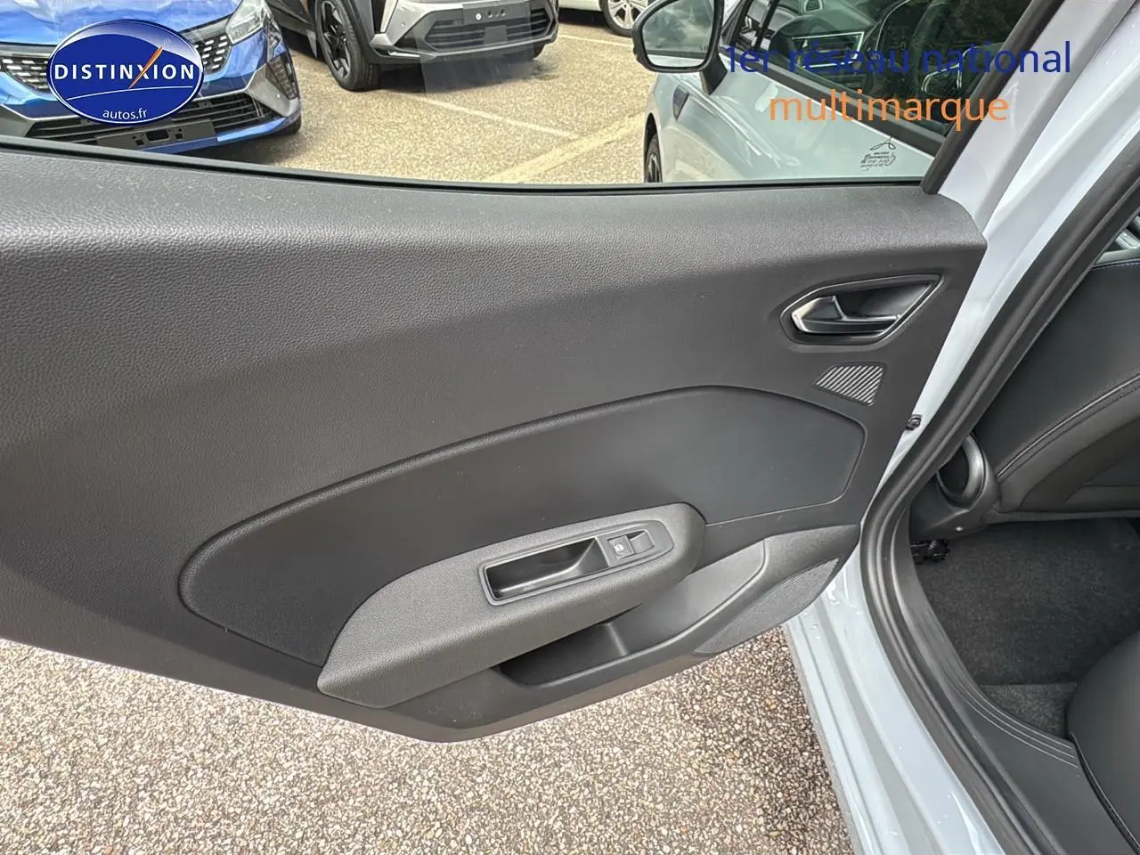 Porte arrière côté droit ouverte d'une Renault Clio V gris rafale, montrant la garniture intérieure noire et la poignée de fenêtre.