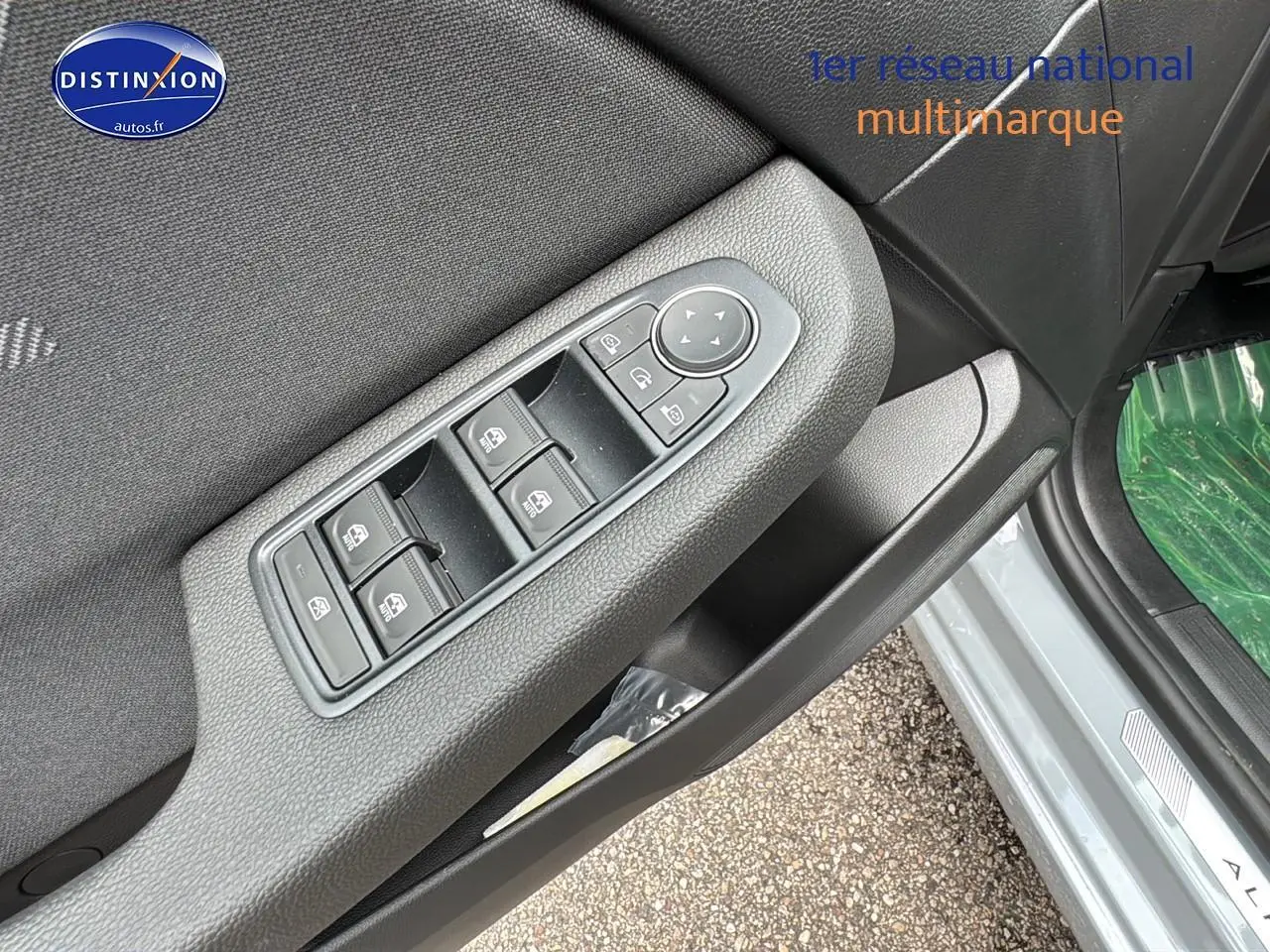 Gros plan sur la commande des vitres électriques côté gauche de la porte d'une Renault Clio V gris rafale.