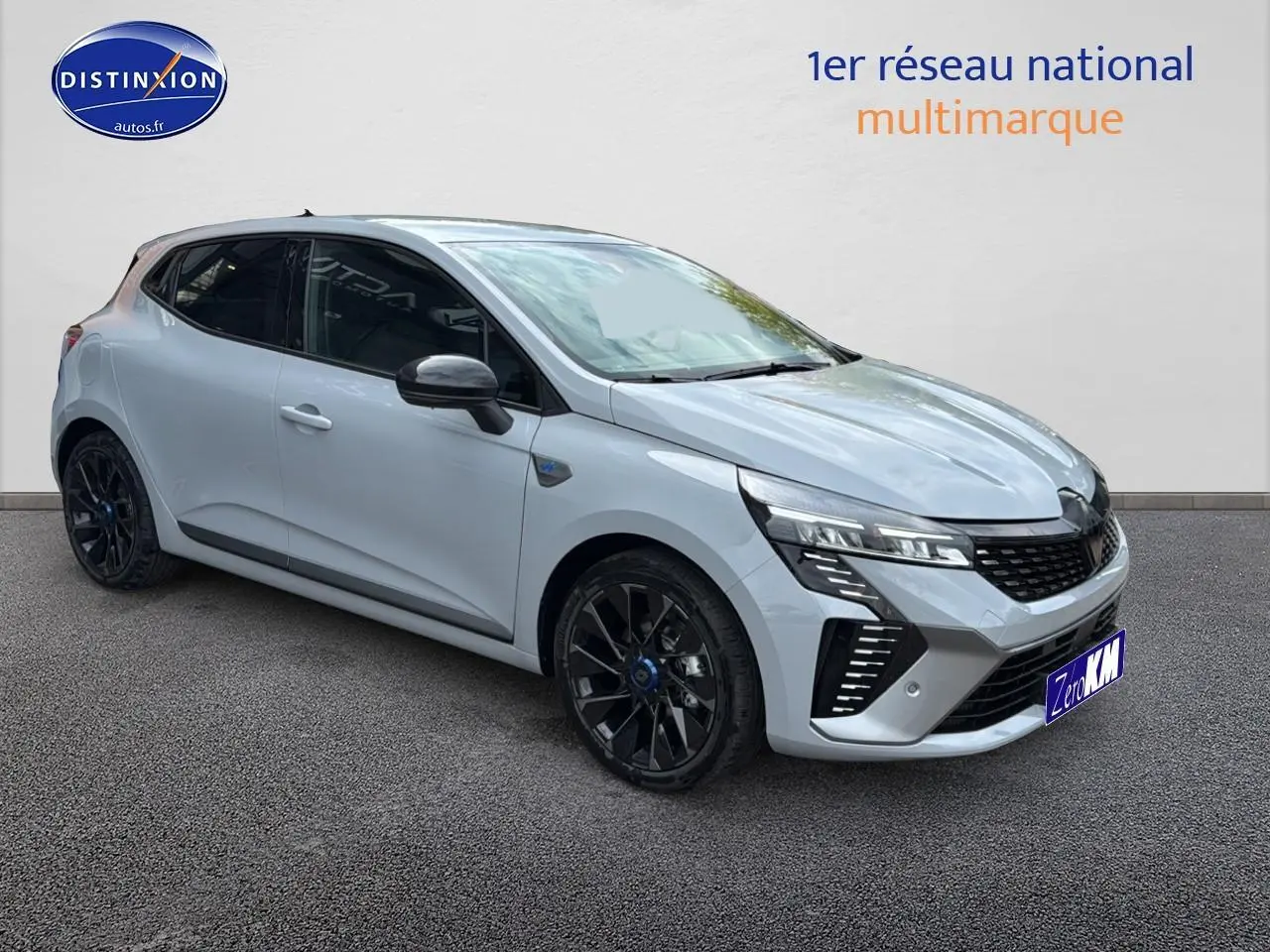 Renault Clio V gris rafale vue 3/4 avant droit avec jantes alu noires esprit alpine et calandre chromée.