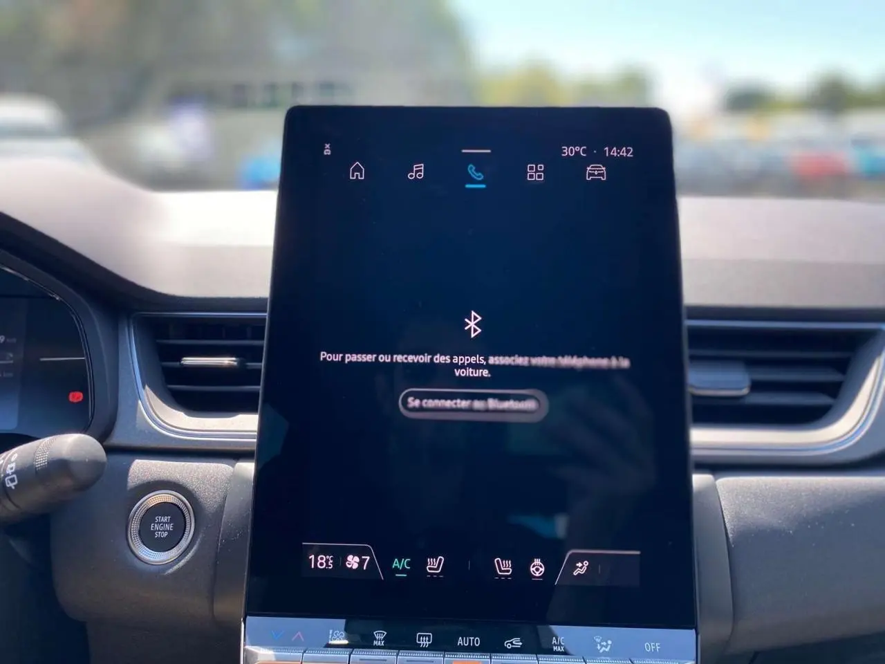 Écran tactile central du tableau de bord du Renault Captur 2025, affichant la connexion Bluetooth et commandes climatisation.
