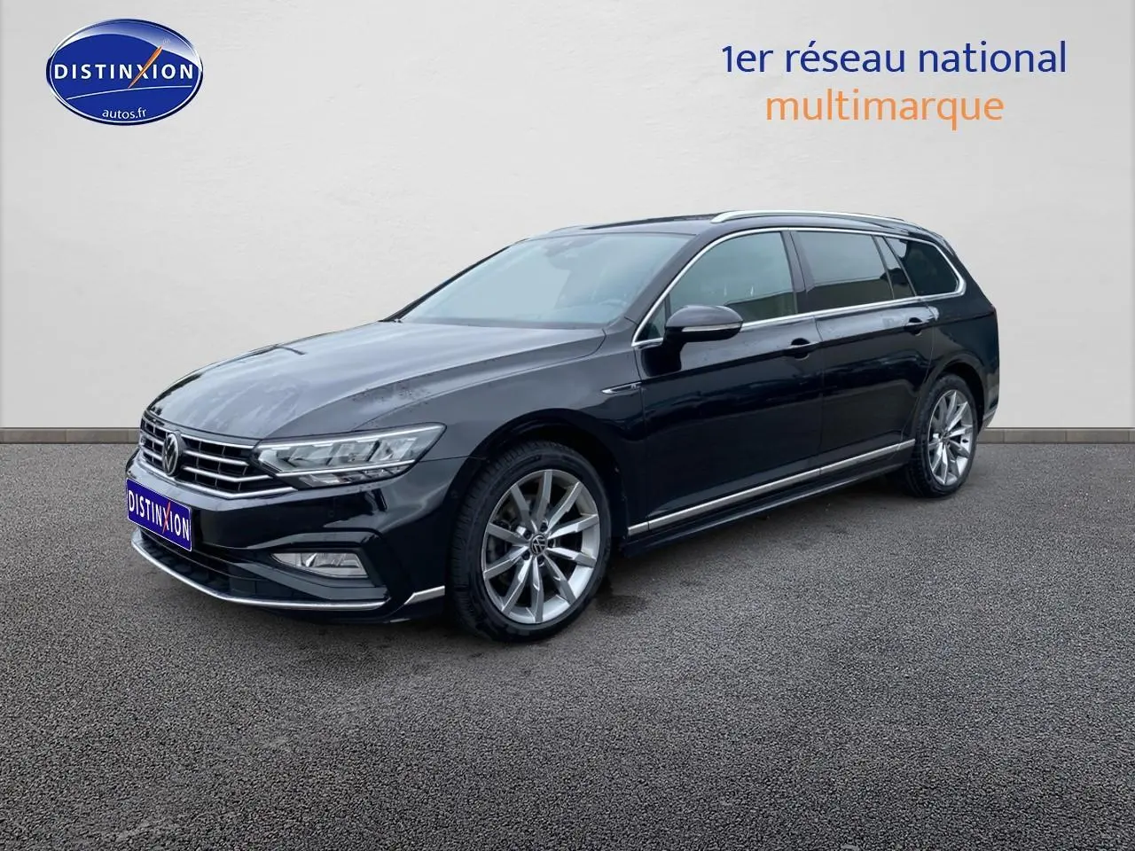 Volkswagen Passat SW noire vue en 3/4 avant droit avec jantes alliage et barres de toit chromées.