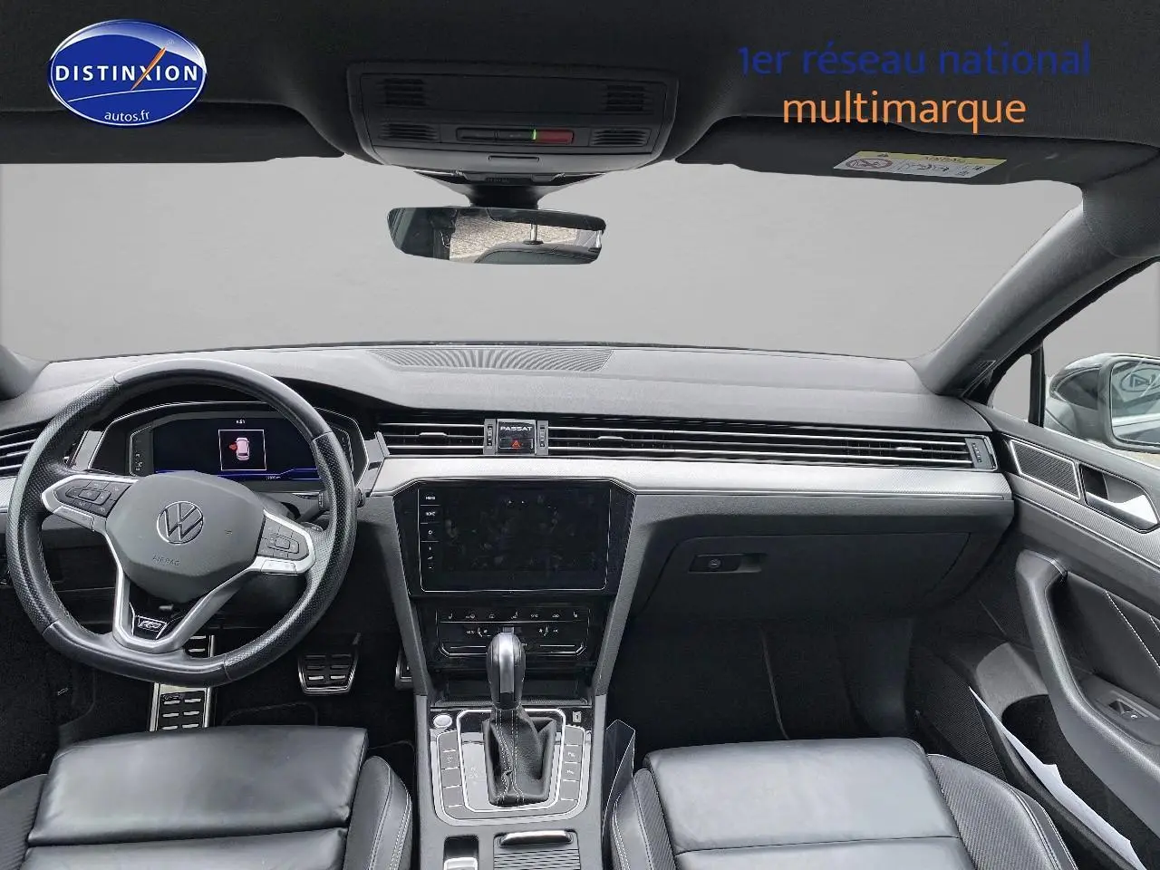 Intérieur noir de la Volkswagen Passat SW 2.0 TDI R-Line 2021, vue frontale du tableau de bord et volant sport cuir.