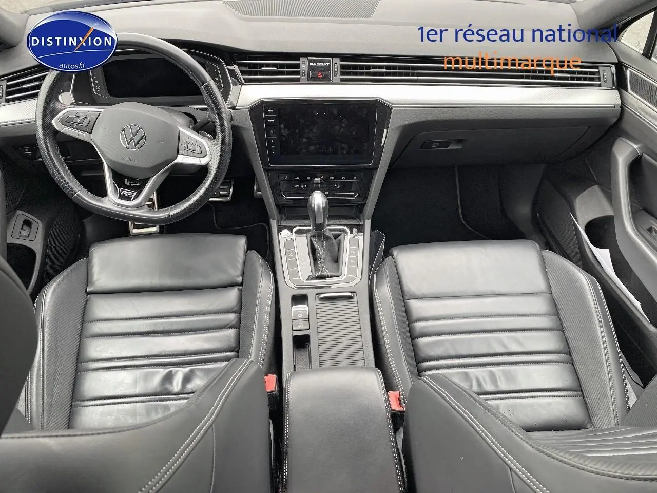 Vue intérieure avant de la Volkswagen Passat SW 2.0 TDI R-Line 2021 avec sièges cuir noirs et console centrale moderne.