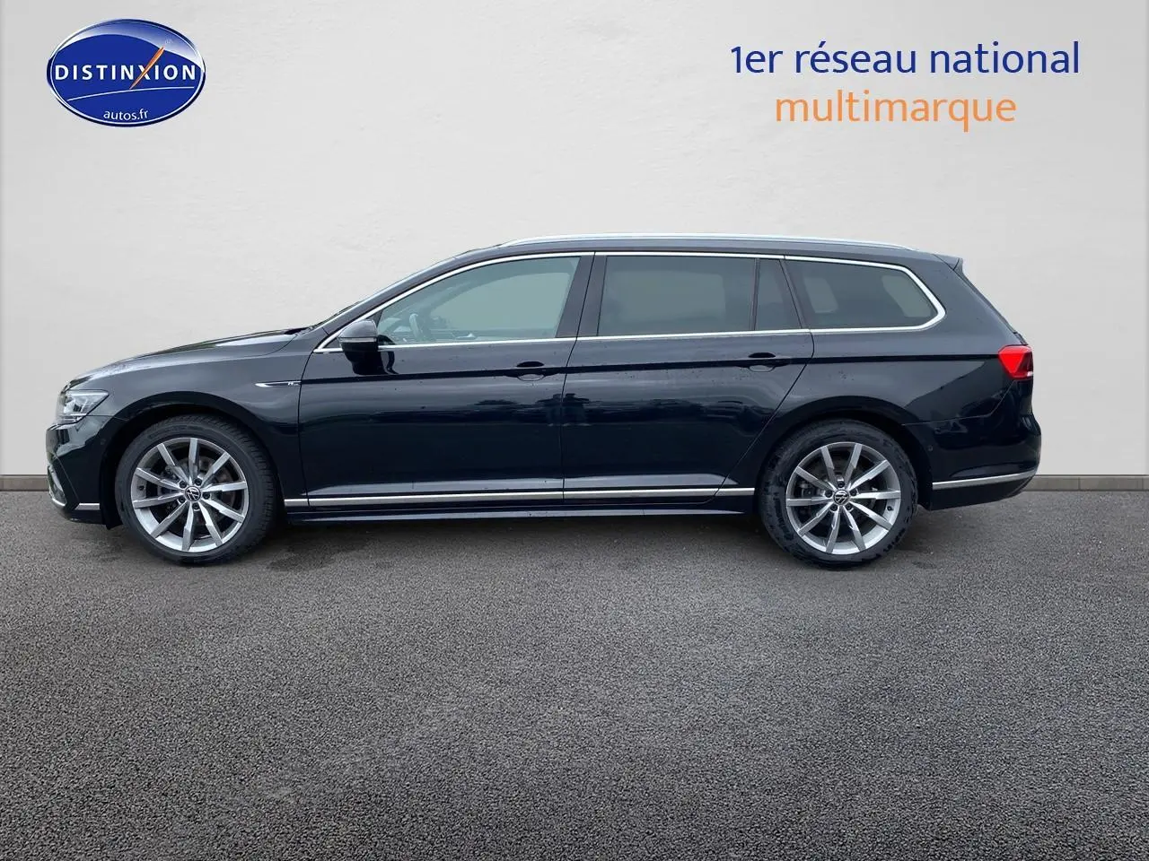 Profil côté gauche d'une Volkswagen Passat SW noire 2021 finition R-Line avec jantes alu et barres de toit chrome.