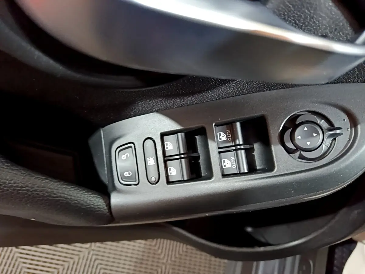 Gros plan sur les commandes des vitres et rétroviseurs côté conducteur d'une FIAT 500X gris foncé, version City Cross 2019.