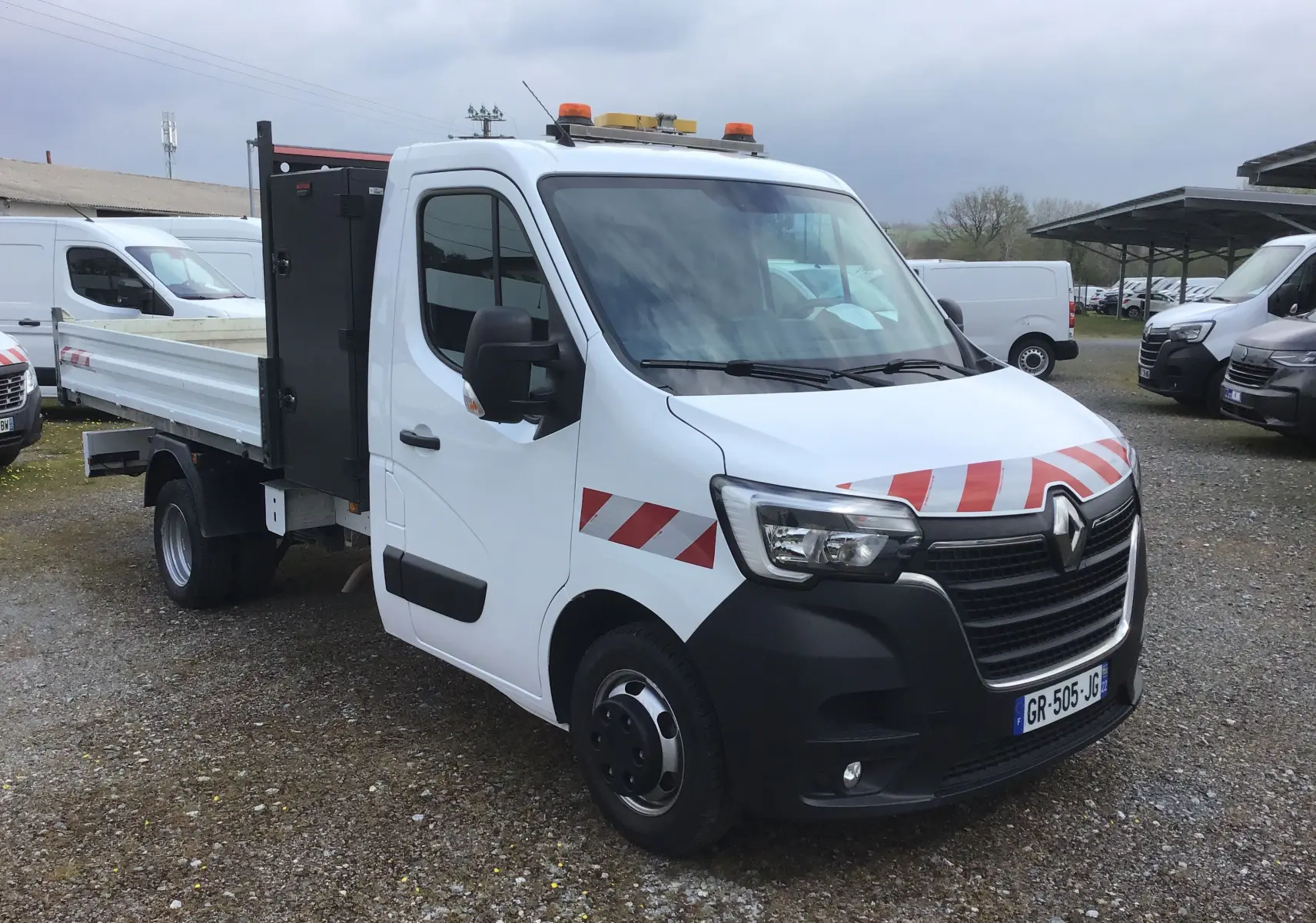Renault Master Châssis cabine blanc vu en 3/4 avant droit avec benne, coffre noir et marquages rouges réfléchissants.