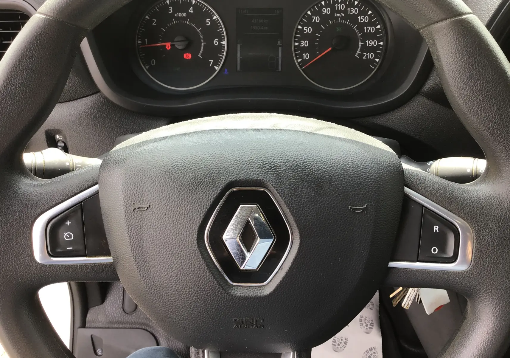 Vue rapprochée du volant noir avec logo Renault au centre et tableau de bord du Renault Master Châssis Cabine blanc.