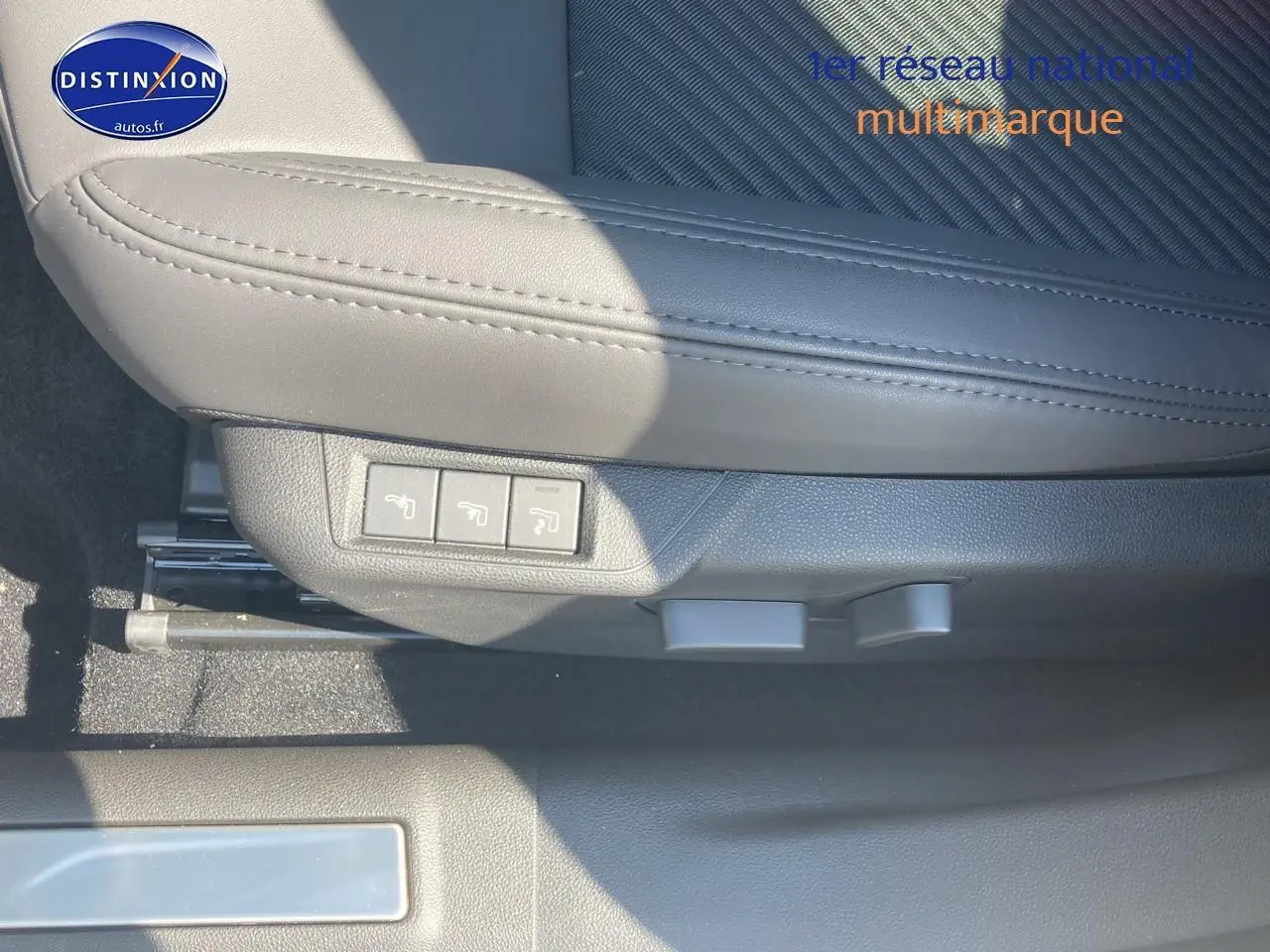 Gros plan sur le côté gauche d’un siège avant gris clair avec commandes électriques dans l’Alfa Romeo Junior 1.2 hybride 2026.