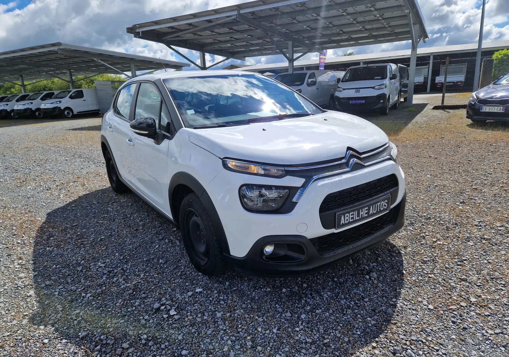 Citroën C3 Société blanc vue 3/4 avant droit, avec calandre noire et feux LED distinctifs, sur parking extérieur.