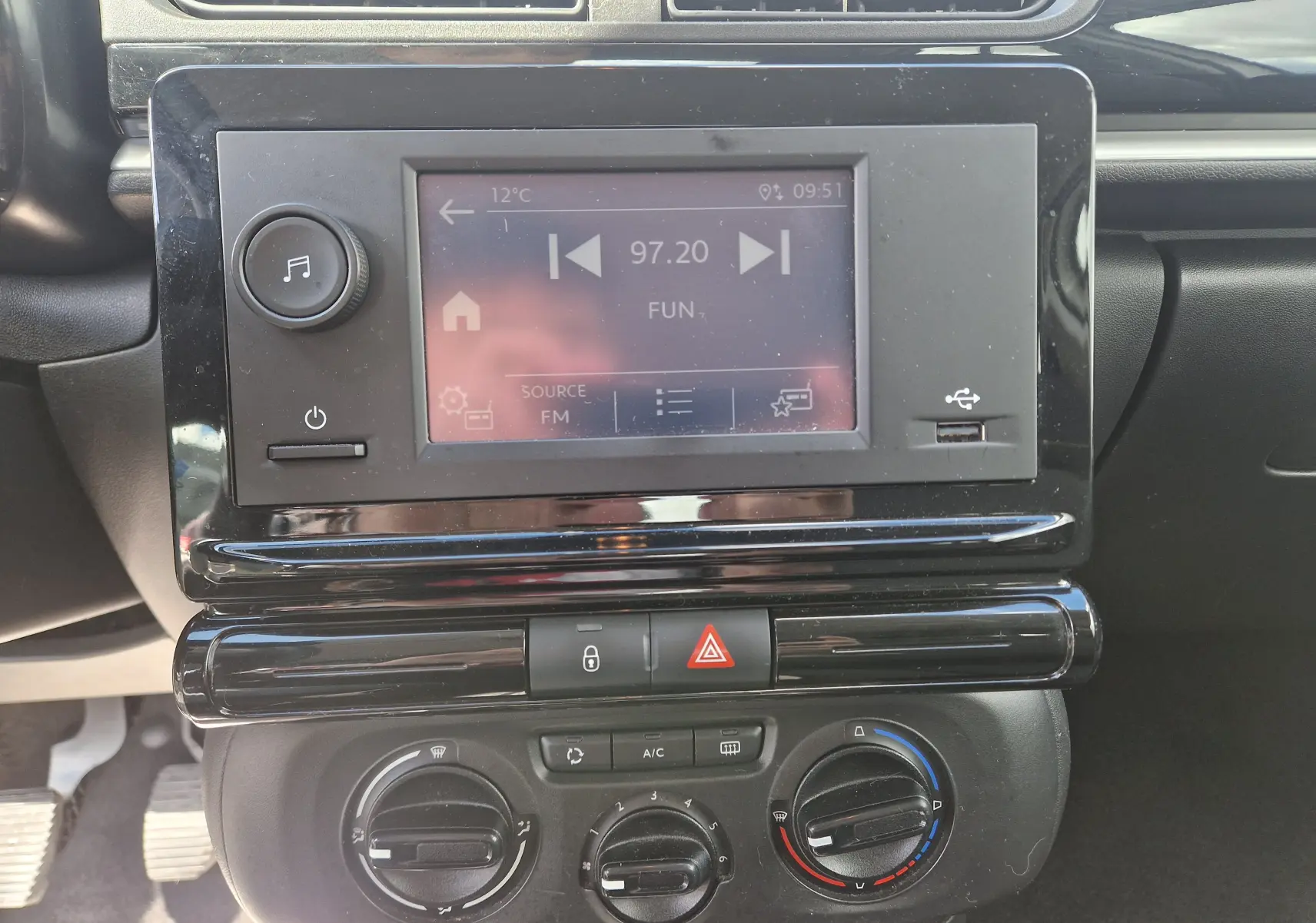 Vue rapprochée du tableau de bord noir de la Citroën C3 Société blanche, avec écran tactile et commandes de climatisation.