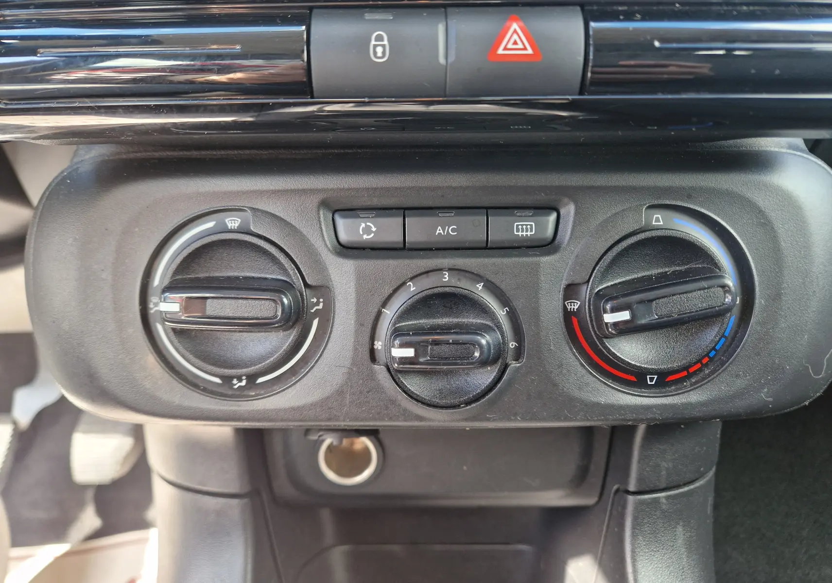 Vue rapprochée du tableau de bord de la Citroën C3 Société blanc, montrant les commandes de climatisation et ventilation.
