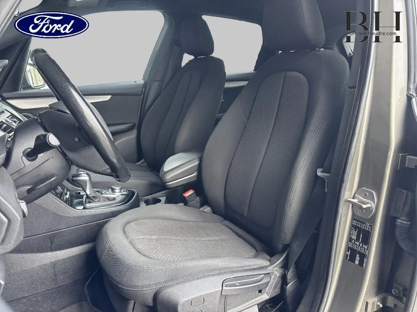 Vue intérieure côté conducteur de la BMW Série 2 Active Tourer 216dA 2015 en Platinumsilber avec sièges tissu anthracite.